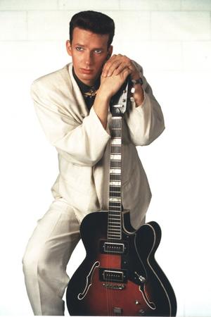 Portrait von Gene mit weißem Anzug und Gitarre